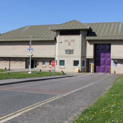 An exterior view of Moorland Prison with its security fences and guard towers.