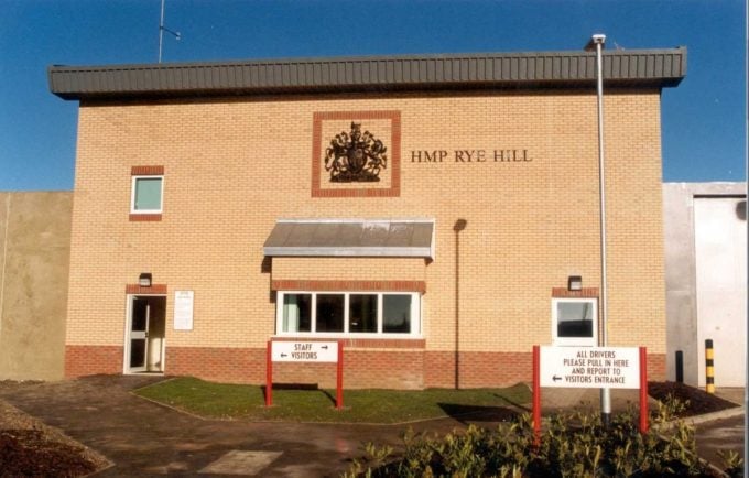 Main entrance of Rye Hill Prison featuring security measures and signage